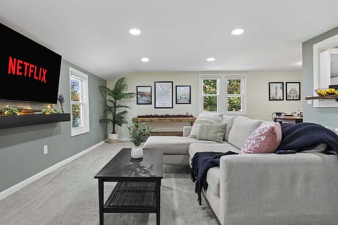 Open concept living with the living room, dining and kitchen area. The living room has a comfy couch, 58" smart TV, and corner swivel chair that's perfect for morning coffee and sight seeing the neighborhood. 