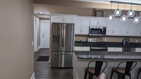 Kitchen, stainless steel appliances, granite counters, island with 4 chairs