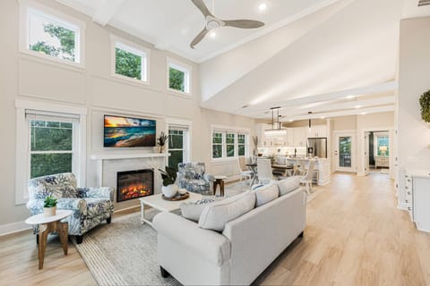 This living room has high ceilings and plenty of natural light, making it feel warm and inviting.