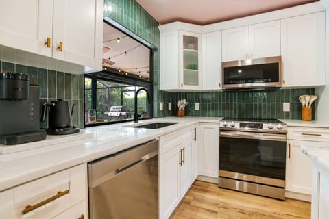 Seamlessly entertain outdoors, the kitchen window transforms into an outside bar