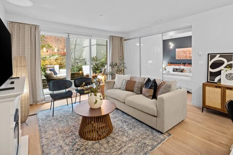 Bright and airy living room with cozy convertible queen sofa bed, and garden views