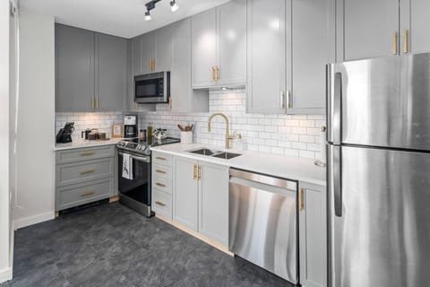 Fully equipped kitchen with sleek appliances and bright subway tile backsplash