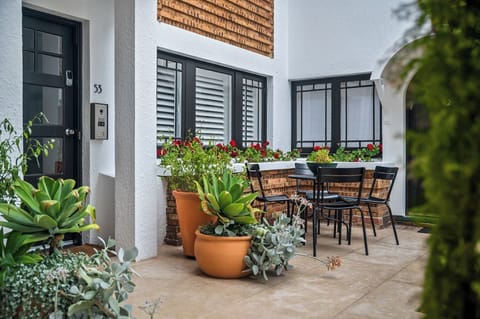OUTDOOR SETTING: Right outside the front door in the sunny landscaped courtyard is a outdoor setting. 