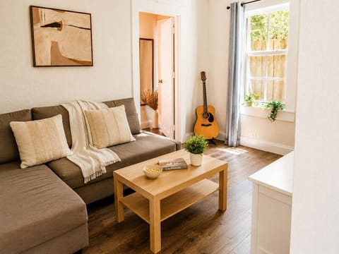 Bright and comfortable living room with a large Smart TV, streaming apps, high-speed Wi-Fi, and cozy seating.