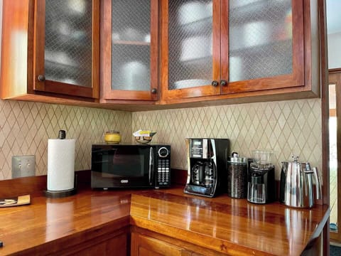 Our coffee set up features: moka pot for espresso, milk frother, large stainless French press, drip coffee maker with reusable filter, coffee grinder, fresh medium roast coffee beans, and an assortment of teas. A hot water dispenser is also built into the sink.