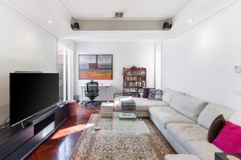 Spacious living room with a cozy sectional, home office setup, and bookshelf.