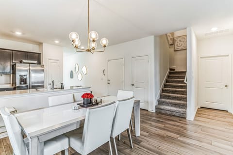 Dining room with 6 chairs and 2 bar stools at the kitchen island