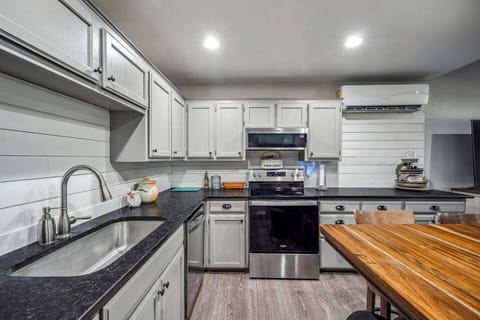 This expansive kitchen includes a refrigerator, stove, oven, and plenty of counter space, making it ideal for preparing meals. The kitchen island adds additional workspace and a gathering spot for guests.