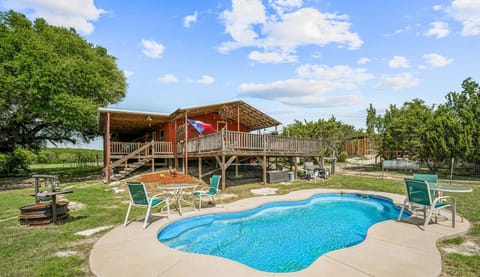 Relax on the spacious wrap-around porch and enjoy the stunning pool area, perfect for swimming or lounging. This outdoor space offers the ideal setting to unwind while enjoying the scenic surroundings.