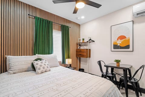 The queen bed is the focal point of this studio, accented by modern, wooden wall paneling and soft linens. It provides a comfortable resting place after a day of exploring.
