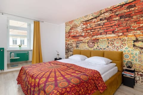 Colorful bedroom with warm tones, eclectic wall art, and a bright atmosphere.