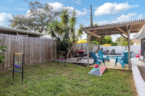 {BACKYARD} The outdoor deck offers comfortable chairs for relaxing and watching cornhole or ladder toss games, while hamburgers sizzle on the grill, creating a great spot for socializing and enjoying the outdoors.