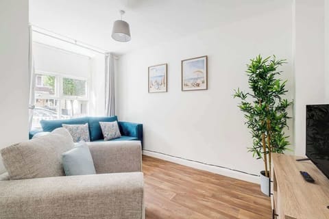 A snug seating area with a soft sofa and armchair makes it easy to relax and enjoy the large TV