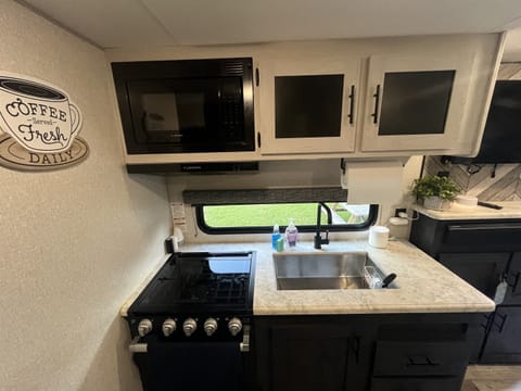 The kitchen has a refrigerator, stove & Oven. Microwave