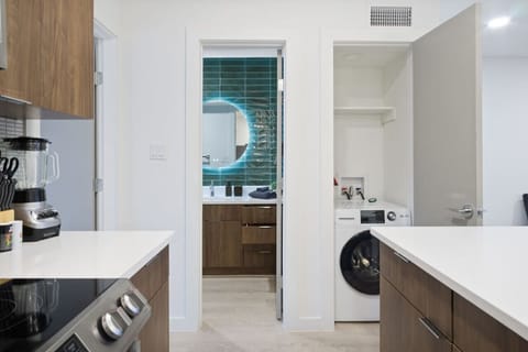 Prepare meals in this modern, fully-equipped kitchen featuring stainless steel appliances and a spacious island with bar seating. The open layout makes it easy to cook and entertain, ensuring a delightful culinary experience during your stay.