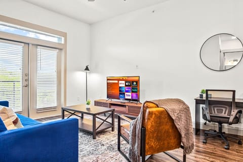 Bright and airy living room with plush seating, a large TV, and tasteful decor, creating the perfect space for relaxation and entertainment.