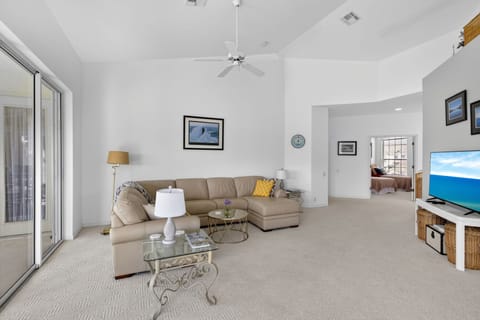 Sectional sofa in spacious living room with vaulted ceilings, open layout and natural light.