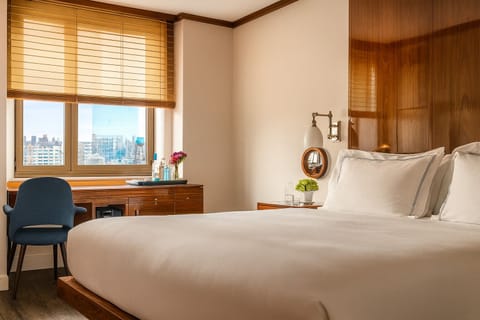 Sink into plush bedding with bright city views ahead.