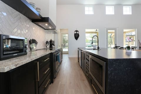 Step into a chef`s dream kitchen, fully equipped with state-of-the-art appliances and ample counter space. The large island and sleek design make this kitchen the perfect spot for cooking and entertaining, with easy access to the outdoor patio.
