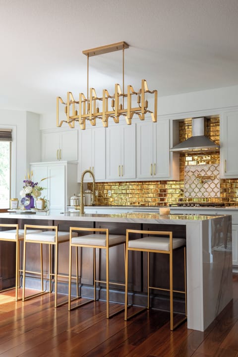 Stunning kitchen with gold accents and marble island.