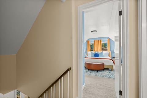 Tranquil retreat: A serene light blue bedroom accented with vibrant, colorful pillows.