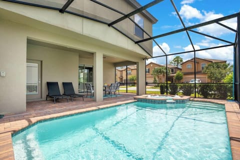 Relax by the screened pool and spa area with outdoor seating in this modern home.