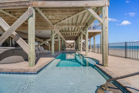Dive into your private pool beneath rustic timber beams, where turquoise waters meet endless ocean views.