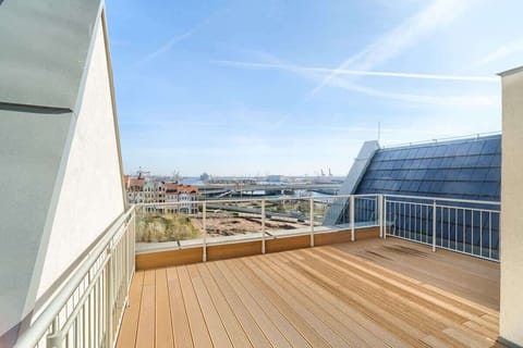 Rooftop terrace with wooden decking and city view.