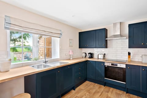 Cook in the modern kitchen at Moat Cottage, with beautiful views of the garden and the stunning North Yorkshire countryside beyond.