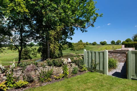 Admire the classic dry stone wall in the garden, framing breathtaking views of the surrounding fields and countryside beyond.
