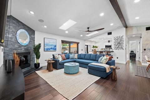 Spacious living room with fire place and ceiling fan