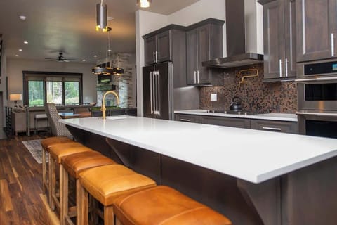 - Gather around the extra long island with leather stools for drinks or conversation
- Plenty of counter space and top tier appliances make cooking a breeze
- Entertain or unwind while staying connected to the open layout