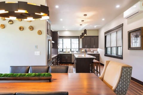 - Dine beneath a bold modern chandelier with garden inspired decor and soft lighting
- Sleek lines meet warm tones in this open, welcoming dining space
- Ideal for family meals, toasts, or late night board games

