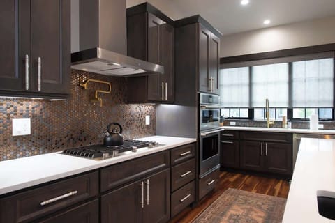 - Cook in style with a sleek gas range, artisan backsplash, and built in double ovens
- Enjoy rich cabinetry and brass accents that blend function and flair
- Whether breakfast or dinner, this kitchen is fully equipped

