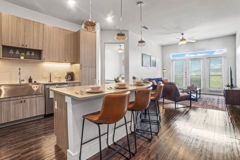 Prepare meals in this modern, fully-equipped kitchen featuring stainless steel appliances and a spacious island with bar seating. The open layout makes it easy to cook and entertain, ensuring a delightful culinary experience during your stay.