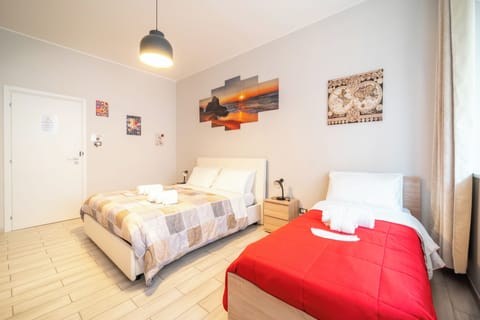 Letto matrimoniale a due piazze con lettino con kit di 3 asciugamani per ospite.
