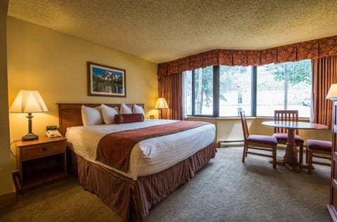 Comfortable bedroom with large windows and a serene view, perfect for unwinding.