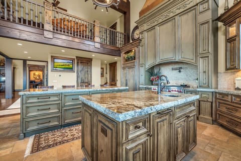 Kitchen at a Luxury Park City vacation rental, marble counters, wooden shelves.