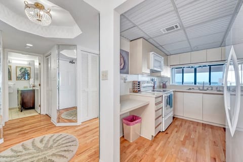 Bright hallway leading into the kitchen w/ warm wood floors & clean lines.