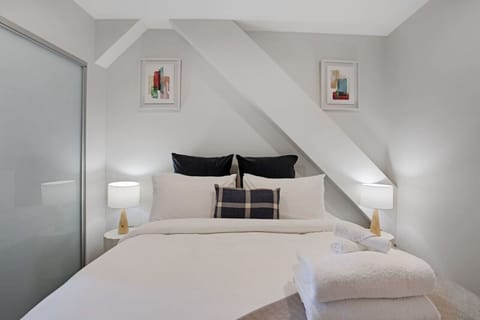 The bedroom features a Queen bed and architectural details in the beam.