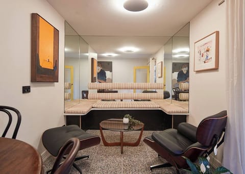 The space expands and light reflects artfully in this cosy lounge nook. 
