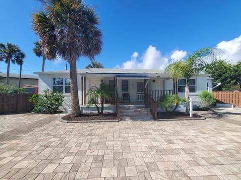 Charming cottage with lush landscaping and a spacious patio.
