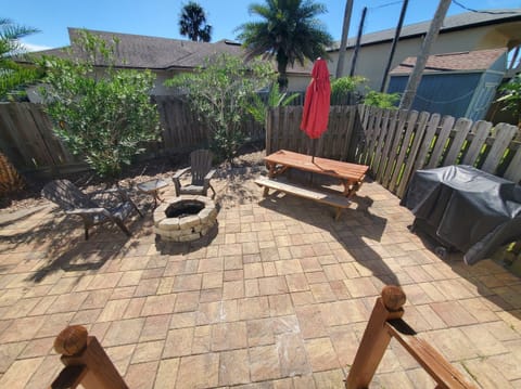 Private backyard with a firepit and picnic table, perfect for outdoor gatherings.