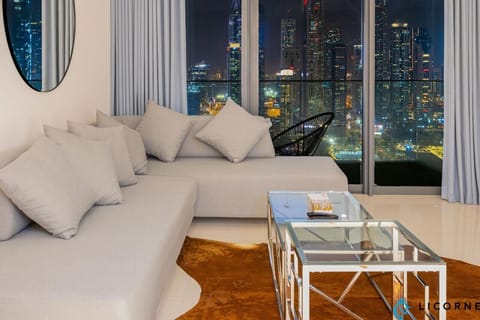 A cozy living room with plush seating, overlooking the stunning Dubai Marina skyline through expansive windows.