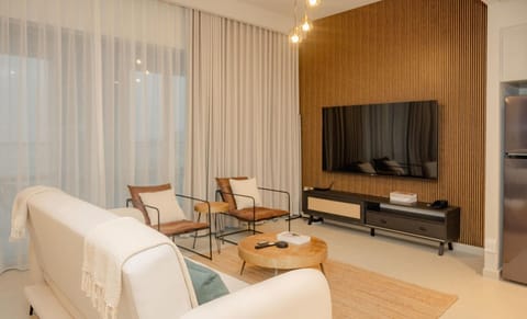 Relax in the stylish and modern living room, complete with a flat-screen TV, comfortable seating, and floor-to-ceiling windows that bring in plenty of natural light.