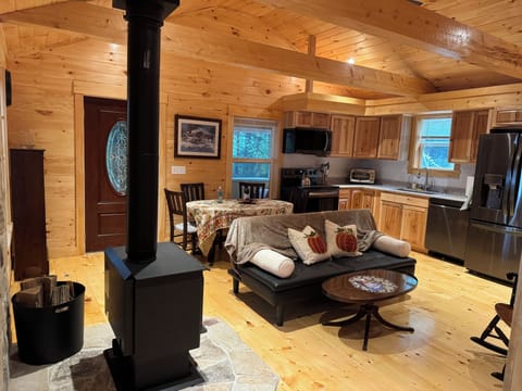 Living room with cast iron wood stove, kitchen with granite countertops.