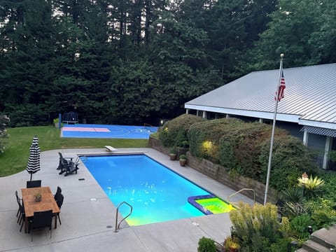 The LED-lit pool and hot tub with the guesthouse on the right. 