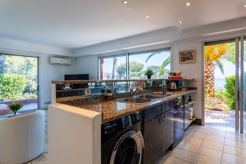 Modern and bright kitchen with a granite countertop. It opens onto a terrace with panoramic sea views.