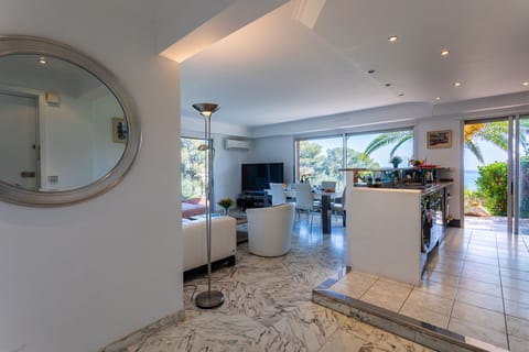 Bright living space with marble flooring, open-plan lounge and dining area, modern kitchen, and garden access.