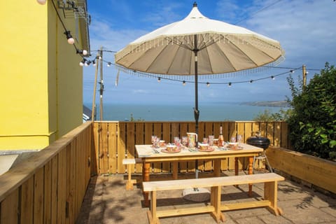 Patio are overlooking the sea with table, benches and parasol